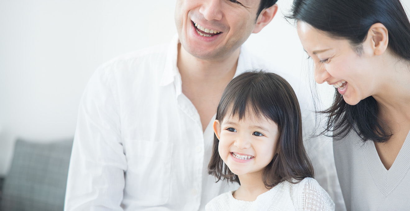 歯科医院の治療室で院長が女の子の口内をチェックしてそのお母さんが見守っている写真