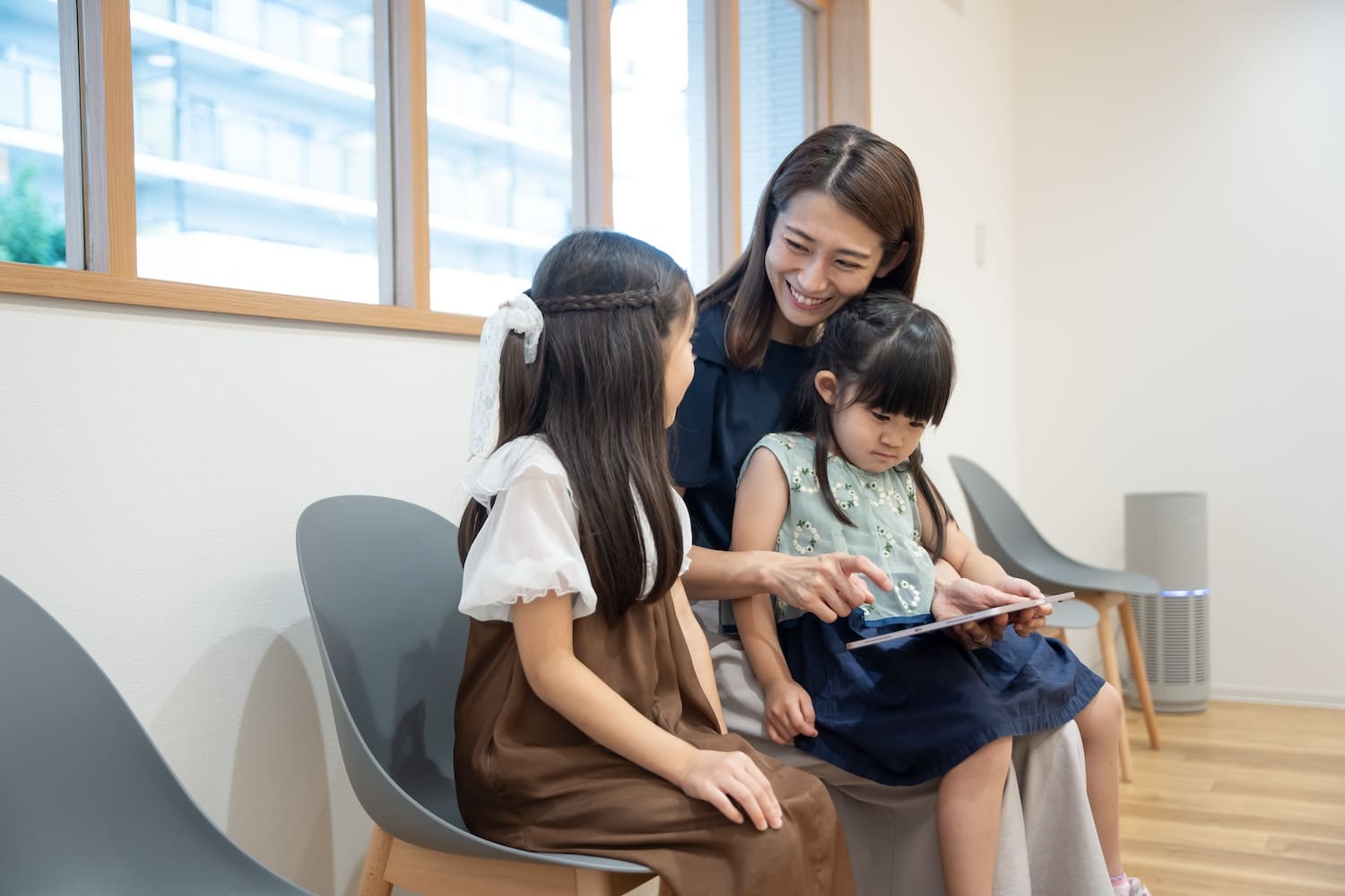 お母さんと2人の女の子が院内で治療の順番を待っている様子