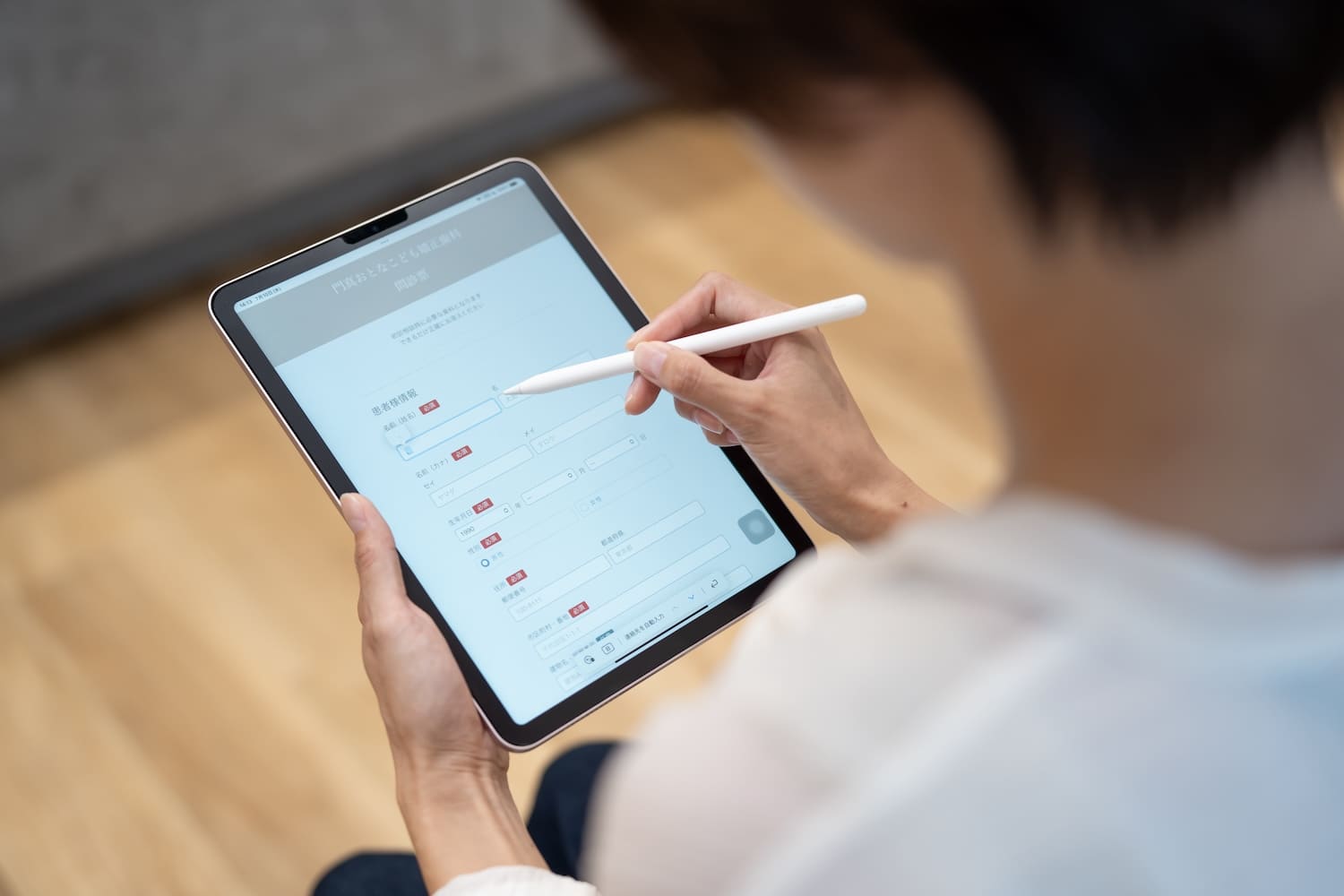 タブレットに表示された問診票に記入している様子